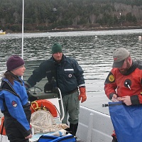 Lee Ann, Mt. Desert Harbor Master Shawn Murphy and Chris check collection bag before dive.